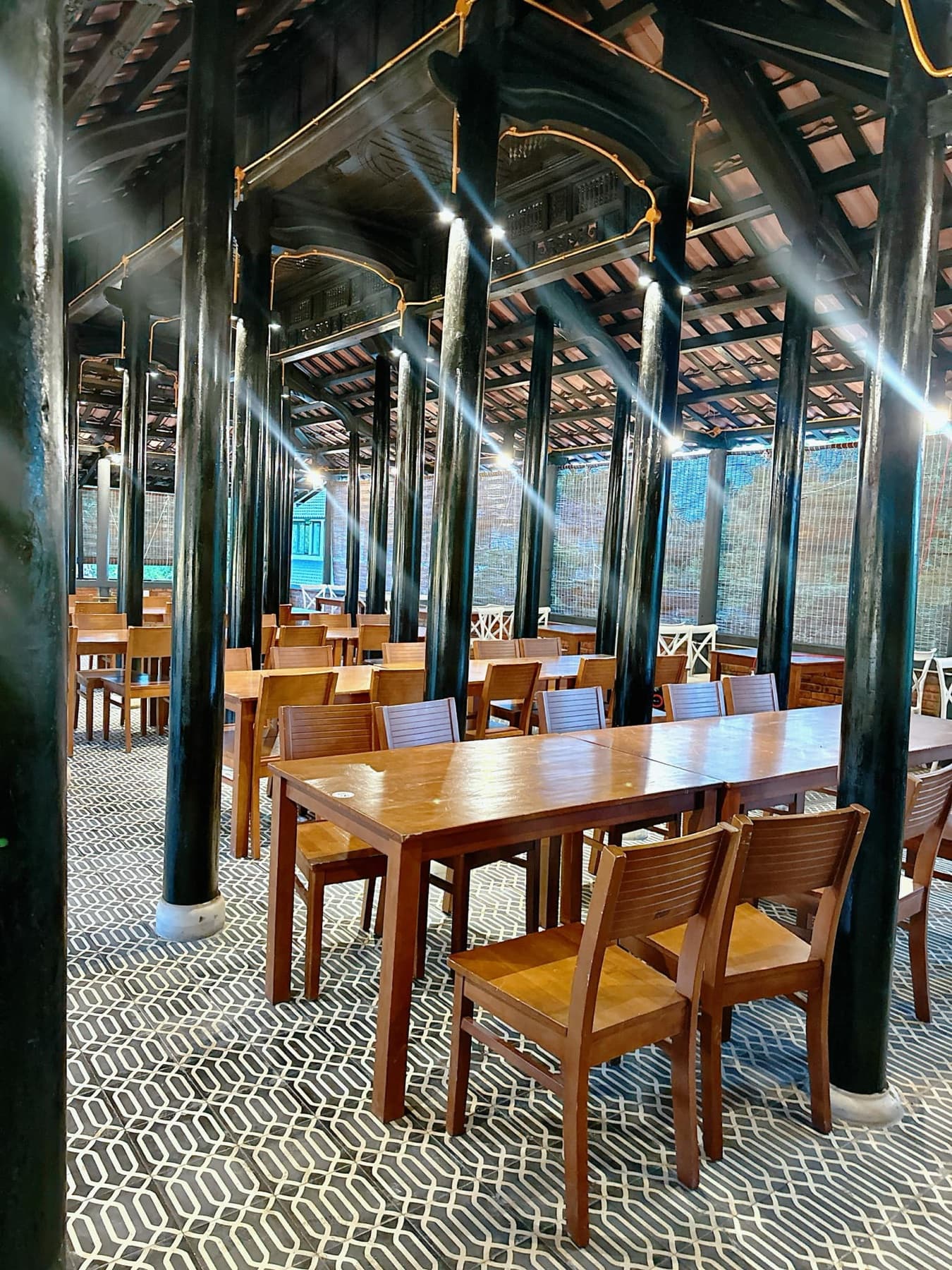 Nhà rường gỗ — Hàng cột sơn then, bàn gỗ và nền gạch hoa